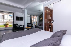 a bedroom with a large bed and a living room at Celenya Hôtel in Toulon