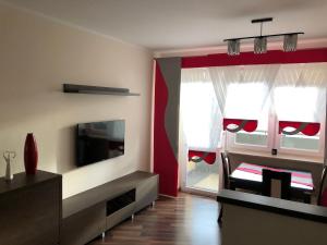 a living room with a flat screen tv and a window at Apartament Tuwima 8 in Ełk