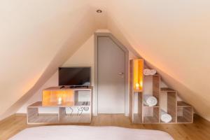 Schlafzimmer im Dachgeschoss mit einem Bett und einem TV in der Unterkunft Bohinj Cottage Pr' Maricki - house in nature with hot tub & sauna in Bohinj