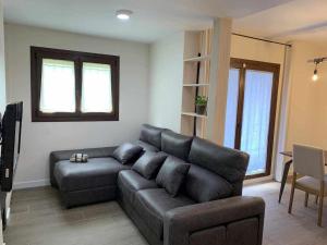 a living room with a black couch and a table at Casa Cotefablo. Alojamiento Ara (Gavin, Biescas) in Gavín