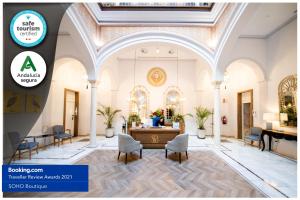 a lobby with a table and chairs in a building at Soho Boutique Sevilla in Seville