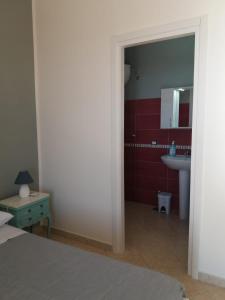 La salle de bains est pourvue d'un lit, d'un lavabo et d'un miroir. dans l'établissement villa lucia, à Mondragone
