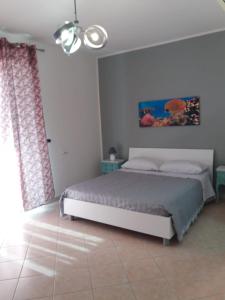 1 dormitorio con 1 cama y una pintura en la pared en villa lucia, en Mondragone