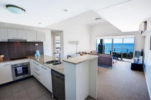 cocina y sala de estar con vistas al océano en The Point Resort en Bargara