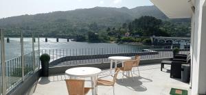 a balcony with tables and chairs and a view of a river at Beira Rio do Gerês in Geres +30 photos