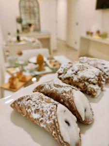 tres pasteles en un plato blanco en una mesa en Il Meraviglioso Mondo di Amélie en Agrigento