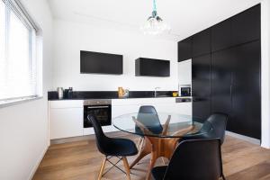 a dining room with a glass table and black chairs at Frishman Dream by Five Stay in Tel Aviv