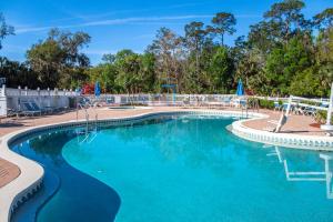 a swimming pool at a resort with blue water at Barefoot'n Resort in Orlando