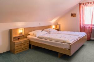 a bedroom with a large bed with a wooden headboard at Haus Hasenweide 