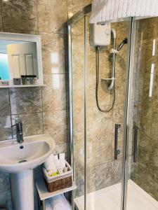 a bathroom with a shower and a sink and a glass shower stall at Parker House Beach & Golf Portrush Free parking in Portrush +27 photos