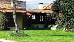 a house with a tree in front of a yard at Quinta do Pomarinho - by RowdHouses in Arouca +16 photos