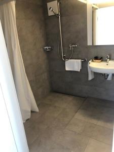 a bathroom with a shower and a sink at Hotel Hippel Krone in Kerzers
