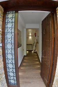 un pasillo con una gran puerta de madera y una escalera en El refugio, en Pinos Genil