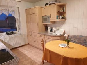 una pequeña cocina con una mesa con un jarrón de flores. en Monteurzimmer Röderland, 