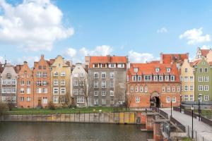 um grupo de edifícios junto a um rio em Grano Residence - Pool, Sauna, SPA & Parking by Downtown Apartments em Gdansk
