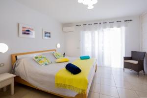 Un dormitorio con una cama con una manta amarilla. en GO2TENERIFE Tropicana Villa Santiago 2, en Playa de las Américas