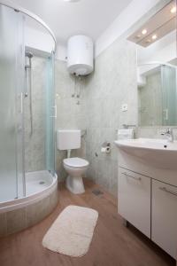 ein Bad mit einem Waschbecken, einem WC und einer Dusche in der Unterkunft Apartman Vite in Podgora