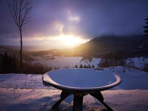 una mesa en la nieve con el sol en el fondo en Kopiše, en Zoll