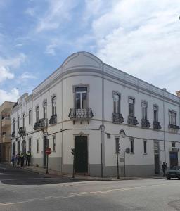 a large white building on the corner of a street at Baron Faro - Guest House in Faro