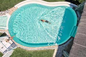 VirósにあるThe Editor's Villa - Member of Spiritual Living Corfuのスイミングプールでの水泳を楽しめる人物の景色