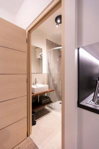 łazienka z umywalką i lustrem w obiekcie Modern studio apartment in the heart of Merano w Meranie