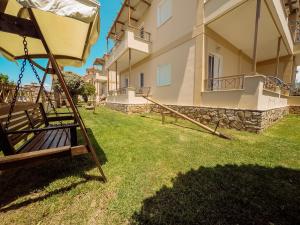 a swing in a yard next to a building at Dream Drop Studios in Kyparissia
