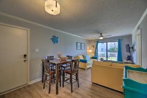 a living room with a table and a couch at Emerald Isle Resort-Style Condo Walk to Beaches! in Emerald Isle