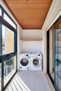 カルカヴェロスにあるCarcavelos Apartmentの洗濯機、乾燥機、窓のそば