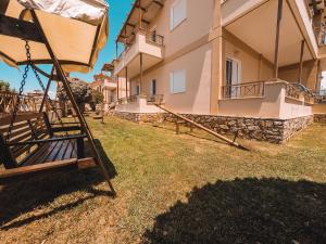 a swing in a yard in front of a building at Dream Drop Studios in Kyparissia +5 photos