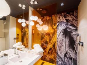 un bagno con un grande dipinto sul muro di Mercure Valence a Valence