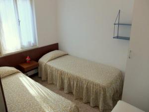 a room with two beds and a window at Lignano cheap in Lignano Sabbiadoro