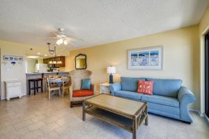 a living room with a blue couch and a table at Commodore Resort #707 by Book That Condo in Panama City Beach