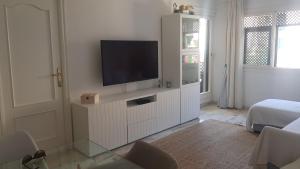 una sala de estar con TV en un armario blanco en Apartamento La Mezquita, en Santa Pola