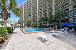 a swimming pool with lounge chairs and a building at Commodore Resort #707 by Book That Condo in Panama City Beach