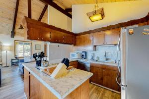 a kitchen with wooden cabinets and a refrigerator at Rockaway Beach House in Rockaway Beach