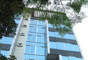 a tall white building with blue glass windows at West Park Inn in Dhaka