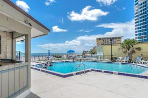 a swimming pool with the ocean in the background at Daytona Beach Soaring in Daytona Beach Shores