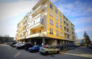 a yellow building with cars parked in front of it at Apartman Nastasijevic in Kladovo