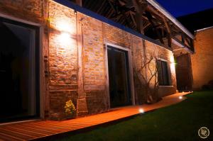 a brick building with lights on it at night at Maison d'hôtes "La Pause Champenoise" in Champfleury +17 photos