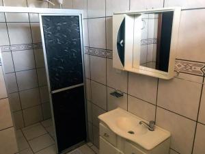 馬沙蒂紐的住宿－Vyalle Hotel，一间带水槽、镜子和淋浴的浴室