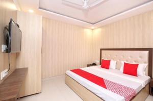 1 dormitorio con 1 cama con almohadas rojas y TV en Forever view near golden temple, en Amritsar