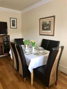 mesa de comedor con sillas negras y mantel blanco en Corner House en Newport