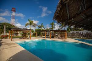 a swimming pool with a pavilion next to a resort at HOTEL & BEACH CLUB OJO DE AGUA in Puerto Morelos