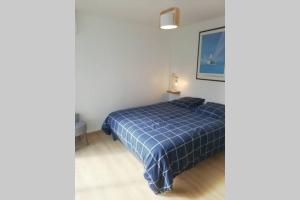 1 dormitorio con 1 cama con edredón azul en Entre Piscine et Mer, en Tonnay-Charente
