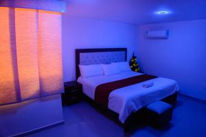1 dormitorio con 1 cama en una habitación azul en Hotel Las Vegas RB, en Ríohacha