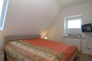 a bedroom with a bed and a window at Am Wasser 4 OG in Hörnum +2 photos