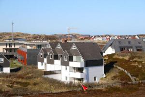 a group of houses on a hill with a red kite at Ferienwohnung Strandrose in Hörnum