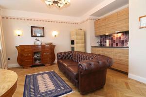a living room with a brown leather couch and a table at Ferienwohnung Art Deco in Hörnum