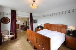 a bedroom with a large wooden bed and a chair at Ferienwohnung Art Deco in Hörnum
