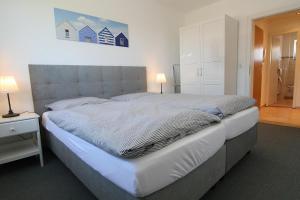 ein Schlafzimmer mit einem großen Bett mit einem großen Kopfteil in der Unterkunft Berliner Ring 5/23 in Hörnum